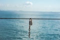 The padlock is fastened to the rope on the background of the sea Royalty Free Stock Photo