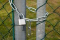 A padlock hanging at a chain-link fence Royalty Free Stock Photo