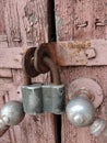 A padlock hangs on a closed door with handles of an ancient house. Shot in close-up Royalty Free Stock Photo