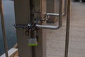 Padlock of iron hanging on a chain, blocking the entrance. Royalty Free Stock Photo