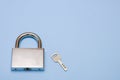padlock and key on a blue background with copy space, security, reliability Royalty Free Stock Photo