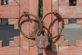 Padlock and metal rings on weathered painted vintage wooden gates. Royalty Free Stock Photo