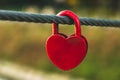 Padlock of shape of heart on a rope. Red heart on a metal cable. Symbol of love, romantic concept. Royalty Free Stock Photo