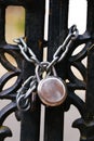 Padlock and strong steel chain wrapped around the metal entrance gate