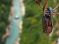 A large padlock hanging on a bridge over a green gorge with a river