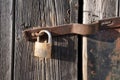Padlock on wooden door close up. Old wood door texture. Close up view old rusty latch and pins with padlock. Royalty Free Stock Photo