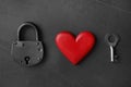 Padlock, wooden heart and key on black stone background, flat lay. Relationship problems concept Royalty Free Stock Photo