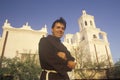 Padre stands in front of Mission San Xavier Del Bac, erected between 1783 and 1897 in Tucson Arizona