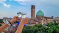 Padua - Couple clinking prosecco glasses with scenic view on Basilica di Santa Maria del Carmine in Padua, Veneto, Italy, Europe