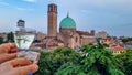 Padua - Couple clinking prosecco glasses with scenic view on Basilica di Santa Maria del Carmine in Padua, Veneto, Italy, Europe