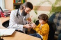 Paediatrician doctor examining a child in comfortabe medical office Royalty Free Stock Photo