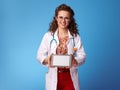 Paediatrician doctor showing tablet PC blank screen on blue Royalty Free Stock Photo