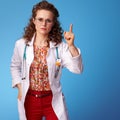 Paediatrist doctor with raised finger on blue