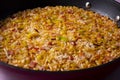 Paella with bacon, leeks, broccoli, carrots, onion and other vegetables.