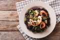 Paella from black rice with seafood close-up on a plate. horizon Royalty Free Stock Photo