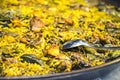 Paella chicken and rabbit dish in its pot served on the table with white tablecloth