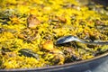 Paella chicken and rabbit dish in its pot served on the table with white tablecloth Royalty Free Stock Photo