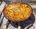 Paella from chicken, vegetables and rice. The national Spanish dish of paella in a large skillet is cooked on an open fire, at the Royalty Free Stock Photo