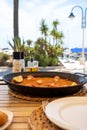 Paella de arroz a banda with red prawns in the port of Altea, with views of the boats