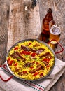 Paella Dish and Beer on Rustic Wooden Table Royalty Free Stock Photo