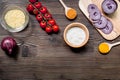 paella ingredients with rice, salt, spices and tomatoes on wooden table background top view mockup