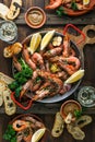 Paella pan with roasted tiger shrimps and many dishes, bread and wine Royalty Free Stock Photo