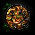 Paella with seafood, prawns, mussels, and shrimps in a pan on black background