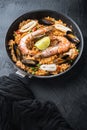 Paella traditional spanish dish served in frying pan, on black textured surface Royalty Free Stock Photo