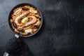 Paella traditional spanish dish served in frying pan, on black textured surface, top view with space for text Royalty Free Stock Photo