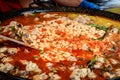 Paella Valenciana being cooked at a street food market, traditional food with white beans, chicken meat, tomato sauce and spices, Royalty Free Stock Photo