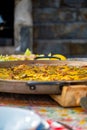Paellera handle with a freshly cooked authentic Valencian paella, to serve on a table with the dishes set Royalty Free Stock Photo