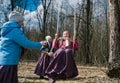 The pagan festival of spring. Children swinging on high swing, against the background of a spring forest