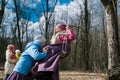 The pagan festival of spring. Children swinging on high swing, against the background of a spring forest