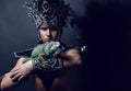Pagan priest in ritual suit with green iguana