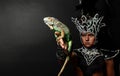 Pagan priest in ritual suit with green iguana