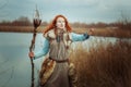 Woman is a shaman with a staff in her hands.