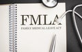 Page with FMLA Family Medical Leave Act on the table with stethoscope, medical concept Royalty Free Stock Photo