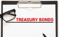 Page of newspaper with words treasury bonds. Trading concept Royalty Free Stock Photo