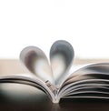 Pages of book curved into heart shape with couple wedding rings Royalty Free Stock Photo