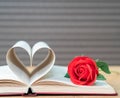 Pages of book curved heart shape and red rose Royalty Free Stock Photo