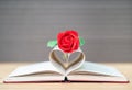 Pages of book curved heart shape and red rose Royalty Free Stock Photo