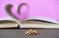 Pages of book curved heart shape and weeding ring Royalty Free Stock Photo