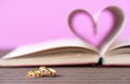 Pages of book curved heart shape and weeding ring Royalty Free Stock Photo