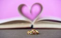 Pages of book curved heart shape and weeding ring Royalty Free Stock Photo