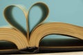 The pages of the book are curved in the shape of a heart. Opened book on a blue background. Back to school theme concept. Royalty Free Stock Photo