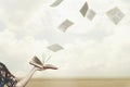 Pages fly free in the sky from a book held open by a woman Royalty Free Stock Photo
