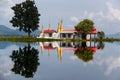 Pagoda with red rooftops and golden spires in the mirroring in Lake Inle, Myanmar/Burma