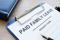 Paid family leave form in clipboard and notepad. Royalty Free Stock Photo