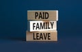 Paid family leave symbol. Concept words Paid family leave on wooden blocks. Beautiful grey table grey background. Business medical