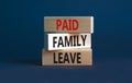Paid family leave symbol. Concept words Paid family leave on wooden blocks. Beautiful grey table grey background. Business medical